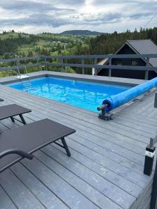 a swimming pool with a blue pipe on a wooden deck at Котедж HOLIDAY HOUSE in Yablunytsya +36 photos