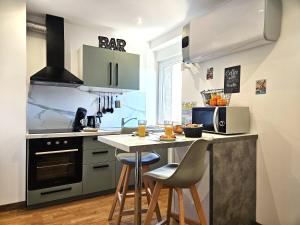 a kitchen with a counter with stools in it at Cosy room - centre ville - 2 pers in Sarreguemines
