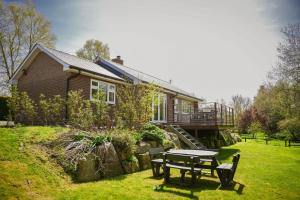 a house with a picnic table in front of it at Ger Yr Afon in Saint Harmon