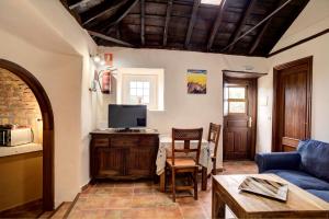 a living room with a blue couch and a tv at Sabina in Mazo