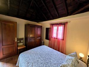 a bedroom with a bed and a red curtain at Sabina in Mazo +13 photos