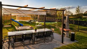 a patio with a table and chairs and a playground at NicePlace4You Familien-Ferienhäuser an der polnischen Ostsee mit Pool in Dobiesławiec