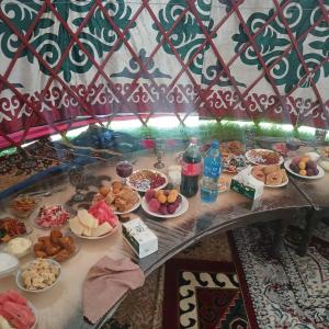 a table with a bunch of food on it at Актан yurt cemp in Chong-Kyzylsu