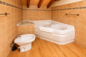 a bathroom with a tub and a toilet and a sink at Llanes Casa cerca Playa y Centro – Encina Pancar in Pancar +32 photos