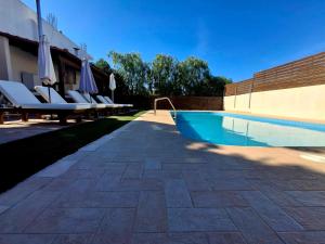 a swimming pool with lounge chairs next to a building at Villa Thalasena in episkopi-heraklion