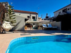 a swimming pool in front of a house at Villa Thalasena in episkopi-heraklion