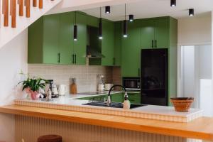 a kitchen with green cabinets and a sink at Terrassi Villa in Angra do Heroísmo