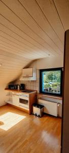 a kitchen in an attic with a large window at Übernachten im Café Restaurant Vedder in Herscheid