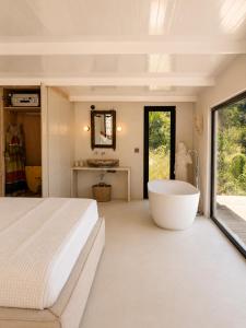 a bedroom with a large white bed and a tub at THE HILL Suite in Ialysos