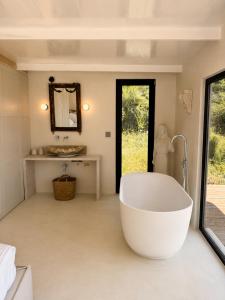 a bathroom with a large tub and a sink at THE HILL Suite in Ialysos