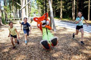 two children playing with a stuffed animal on a playground at Hotel Element in Lipno nad Vltavou