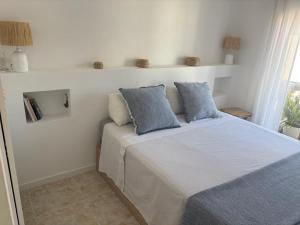 a bedroom with a bed with blue pillows on it at Casa de playa in Roda de Bará +12 photos