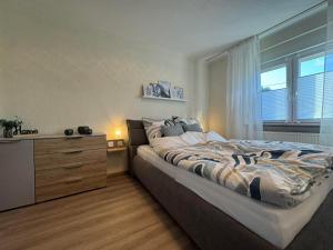 a bedroom with a bed and a dresser and a window at Zur Sonnenseite in Oberthal