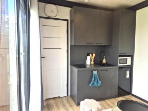 a kitchen with gray cabinets and a clock on the wall at Douce Escale in Vichel