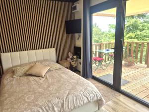 a bedroom with a bed and a balcony with a table at Douce Escale in Vichel
