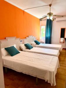 a group of three beds in a room at Hostal Los Arcos Vejer in Vejer de la Frontera