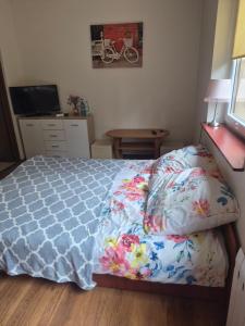 a bedroom with a bed and a desk with a television at Srebrny Świerk in Wambierzyce