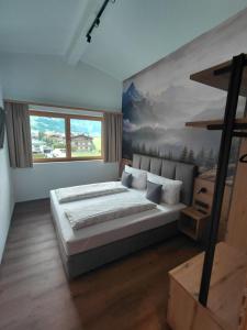 a bedroom with a bed and a painting on the wall at Appartement Schroll in Schwendau