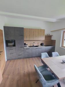 a kitchen with a table and chairs and a table and a counter at Appartement Schroll in Schwendau +2 photos