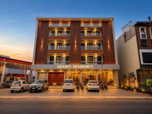 a large building with cars parked in a parking lot at Hotel Shanti Residency Vrindavan in Vrindāvan