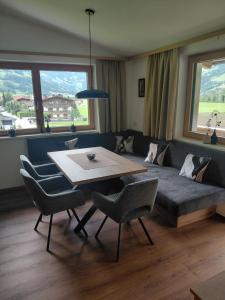 a living room with a couch and a table and chairs at Appartement Schroll in Schwendau