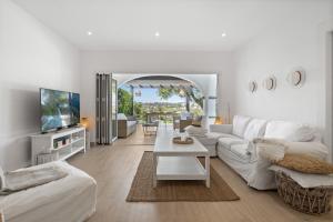 a white living room with a white couch and a table at Las Pergolas in Marbella