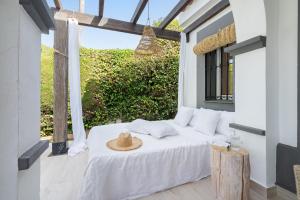 a bedroom with a bed with a straw hat on it at Las Pergolas in Marbella +44 photos