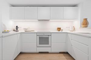 a white kitchen with white cabinets and appliances at Las Pergolas in Marbella