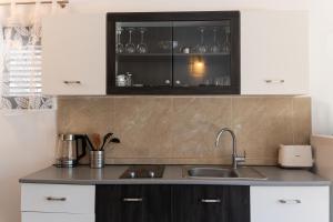 a kitchen with white cabinets and a sink at Apartmani Natal in Donja Lastva +120 photos