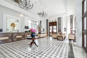 una gran sala de estar con una mesa en el suelo de baldosa en Inna Bali Heritage Hotel en Denpasar