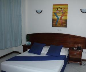 a bedroom with a bed with blue pillows at Residencial Beleza in Mindelo