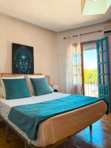 a bedroom with a large bed with a statue on the wall at Hostal Los Arcos Vejer in Vejer de la Frontera +12 photos