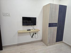 a room with a desk with a tv and a wall at GT Homestay in Chennai +27 photos