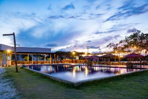 a swimming pool in front of a building at night at AREIA BRANCA Chalés in Santo Amaro