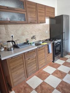 a kitchen with wooden cabinets and a sink and a stove at Srebrny Świerk in Wambierzyce
