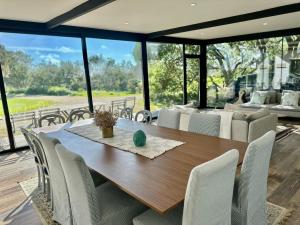 a dining room with a wooden table and chairs at Desertas Beach and Sport in Costa Nova