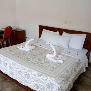 a bed with two swans decorations on it at Hôtel LEWI 1 Bouaké in Bouaké