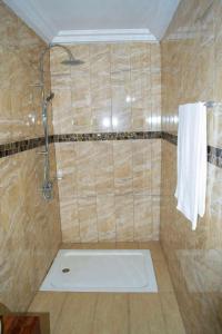 a bathroom with a shower with a white towel at Hôtel LEWI 1 Bouaké in Bouaké