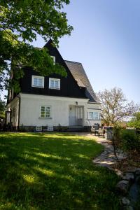 a large white house with a black roof at Vila Vlasta in Bruntál
