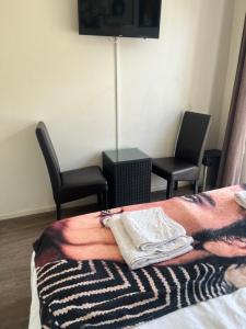 a bedroom with two chairs and a bed with a blanket at Bed & Breakfast Klokgaaf in De Koog
