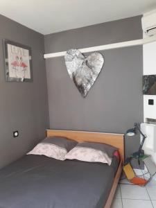 a bedroom with a heart hanging on the wall at Maison MATIASMA avec Jacuzzi in Hyères