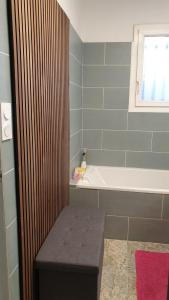 a bathroom with a tub and a bench in it at Maison MATIASMA avec Jacuzzi in Hyères