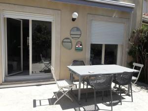 a table and chairs in front of a house at Maison MATIASMA avec Jacuzzi in Hyères