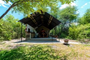 a pavilion with a black roof in a park at Namushasha River Camping2Go in Kongola