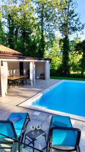 a pool with chairs and a table next to a house at Vila Green Silence in Pazin