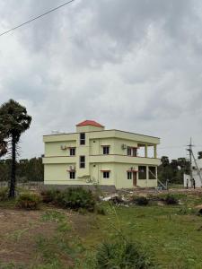 a white building with a tree in front of it at Sagara Darshanam in Vetāpālem