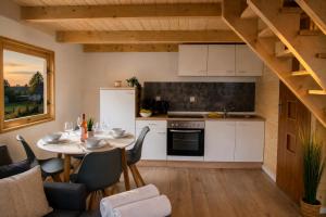 a kitchen and dining room with a table and chairs at NicePlace4You Familien-Ferienhäuser an der polnischen Ostsee mit Pool in Dobiesławiec