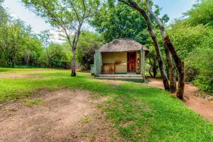 a small building with a grass roof in a field at Namushasha River Camping2Go in Kongola