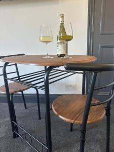 a table with two glasses and a bottle of wine at Self contained property in Cartworth