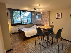 a bedroom with a bed and a table and chairs at Studio Rue de Pommard in Francorchamps